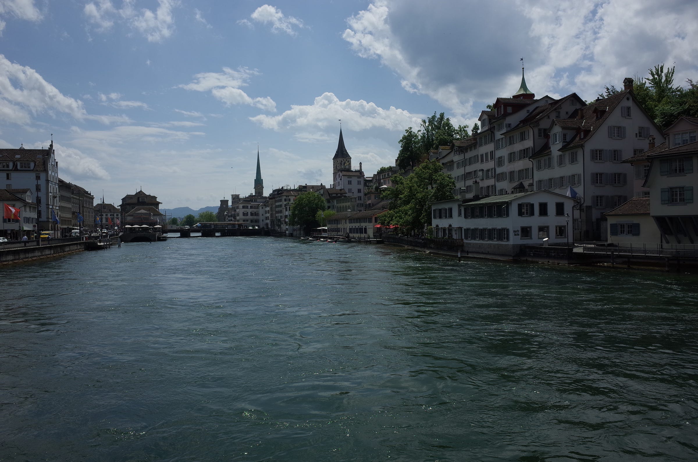 A photograph of the river in Zurich with churches and old buildings in the background