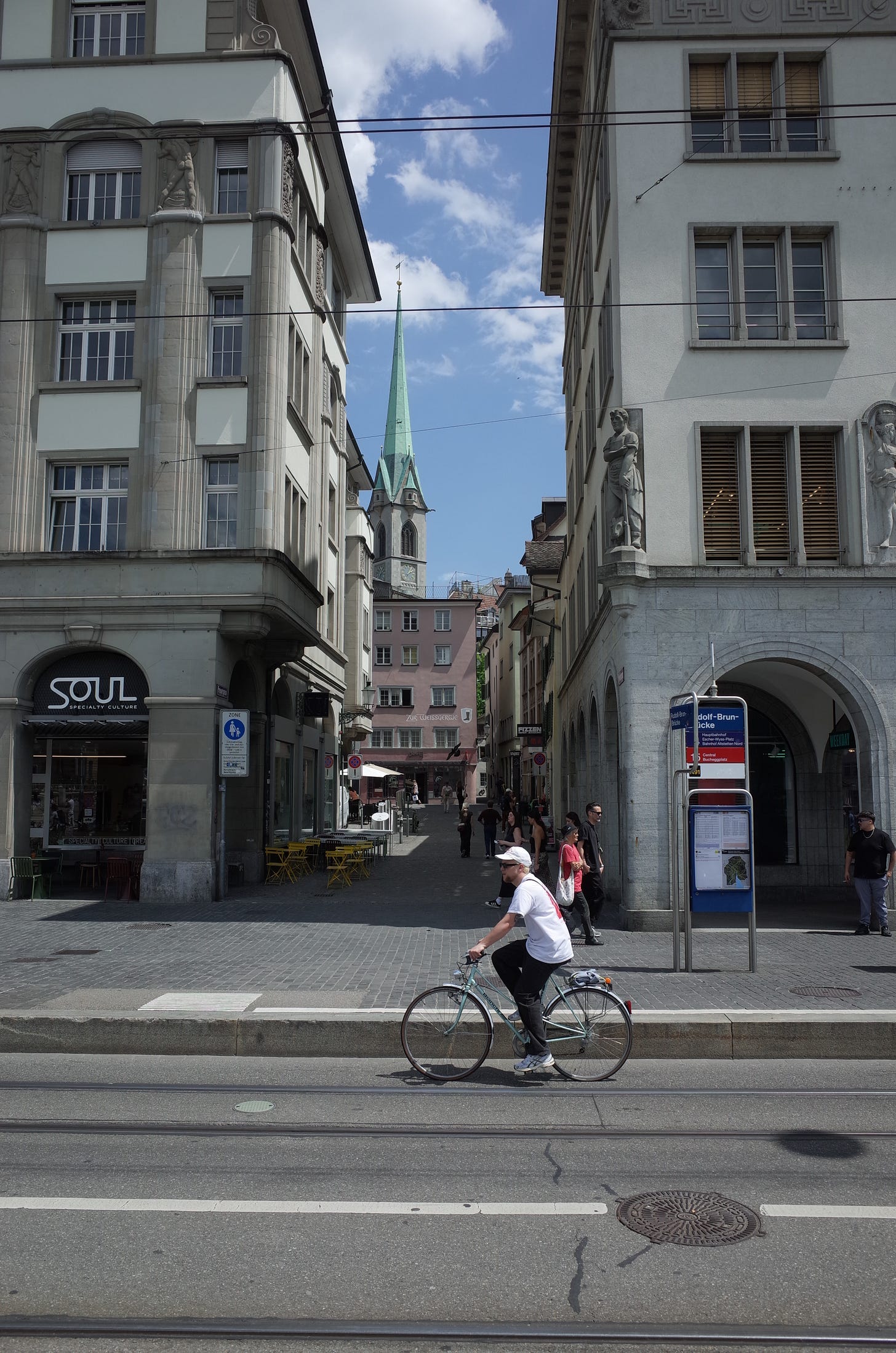 A photograph of a small alley way between two building with the church in the background